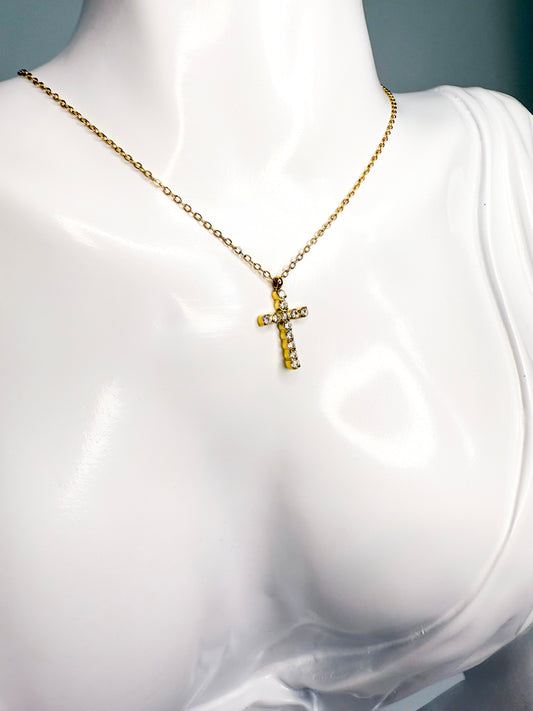 Gold necklace with a cross pendant on a mannequin bust.